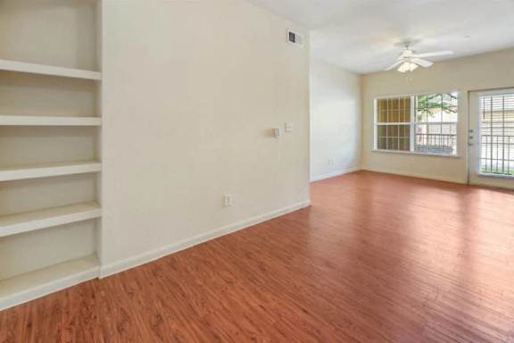 A room with wooden floors and a ceiling fan.