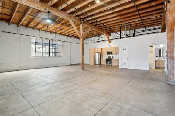 A large empty room with a wooden ceiling and white walls.