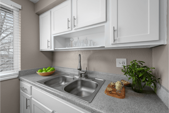 a kitchen with white cabinets and a sink
