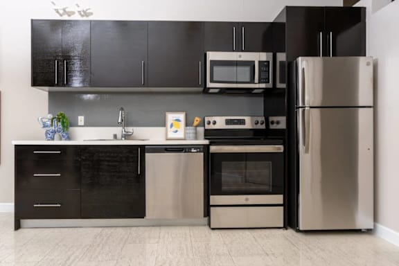 a kitchen with stainless steel appliances and black and white cabinets