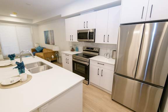 A modern kitchen with stainless steel appliances and white cabinets.
