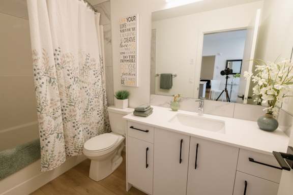 A bathroom with a toilet, sink, and a shower curtain.