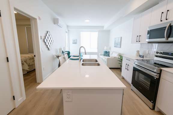 A modern kitchen with white cabinets and stainless steel appliances.