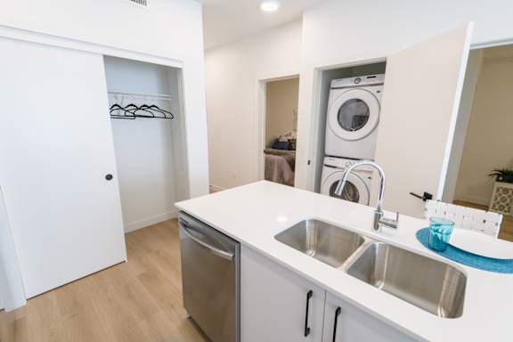 A white kitchen with a washer and dryer built in.