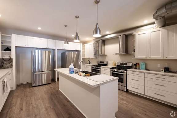 A modern kitchen with white cabinets and stainless steel appliances.