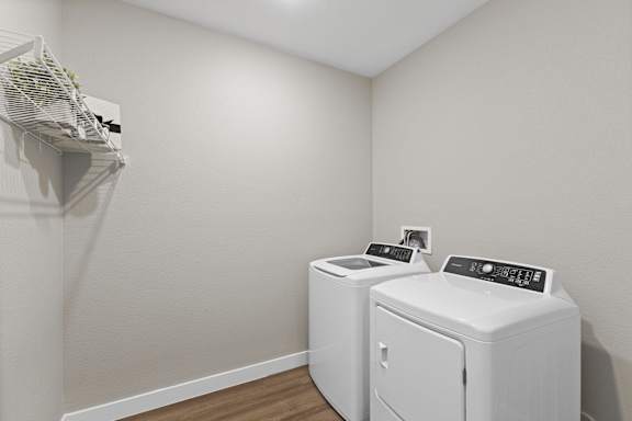 A small laundry room with a washer and dryer at Agave House Apartments, Casa Grande