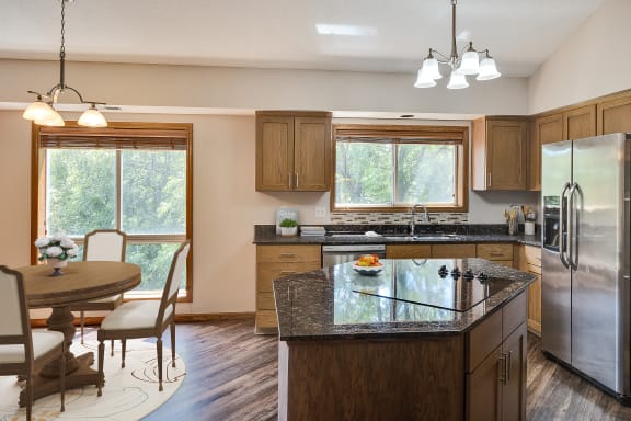 a kitchen with a island and a dining room with a table and chairs