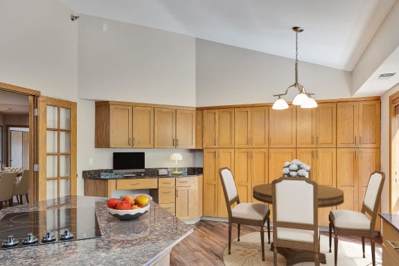 a kitchen and dining room with wooden cabinets and a granite counter top