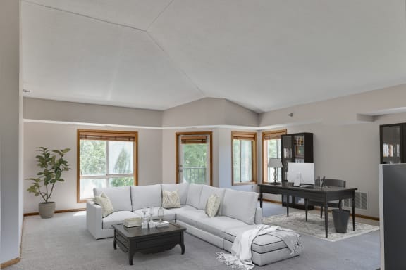 a living room with a white couch and a black table and a piano