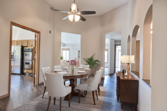 a dining room with a table and chairs and a ceiling fan
