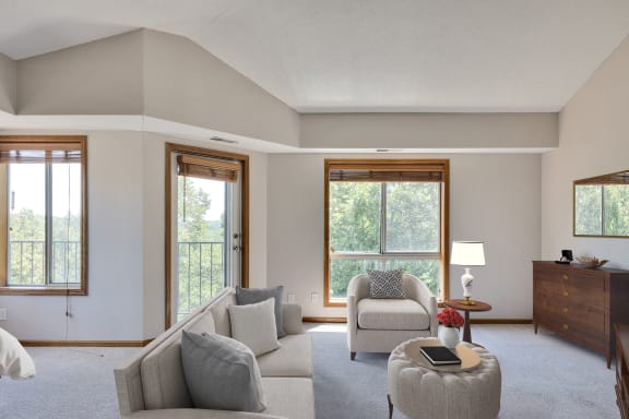 a living room with a couch and a chair and a window
