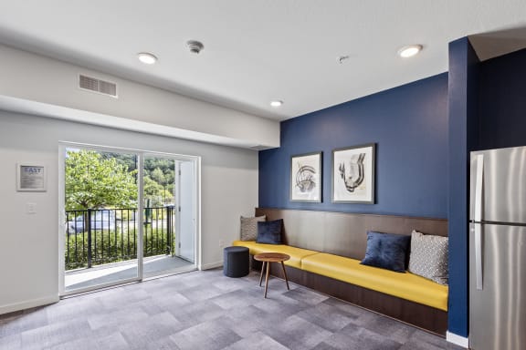 a living room with a yellow couch and a door to a balcony at EastGate Apartments, Minnesota, 55904