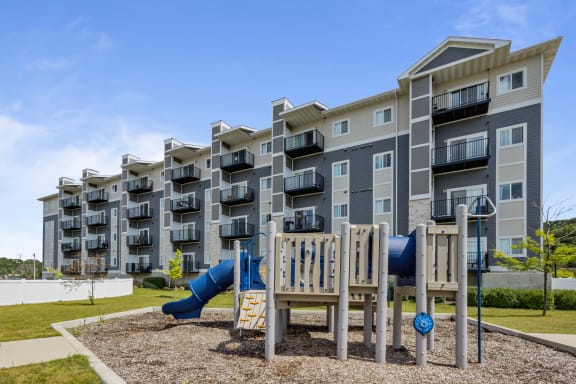 an apartment building with a playground in front of it at EastGate Apartments, Rochester