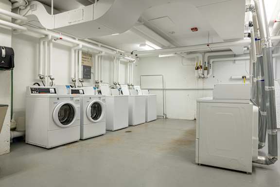 a row of washing machines and dryers in a laundry room at Humboldt Senior 55+ Apartments, Saint Paul, MN, 55107