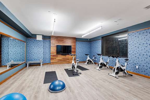 a gym with exercise equipment and a tv on the wall at Press House Apartments, Minnesota