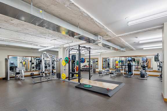 a gym with weights and other exercise equipment in a building at Press House Apartments, Minnesota