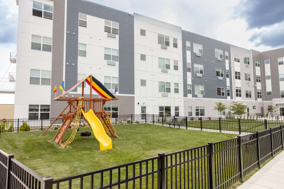 a playground in the middle of an apartment building with a slide