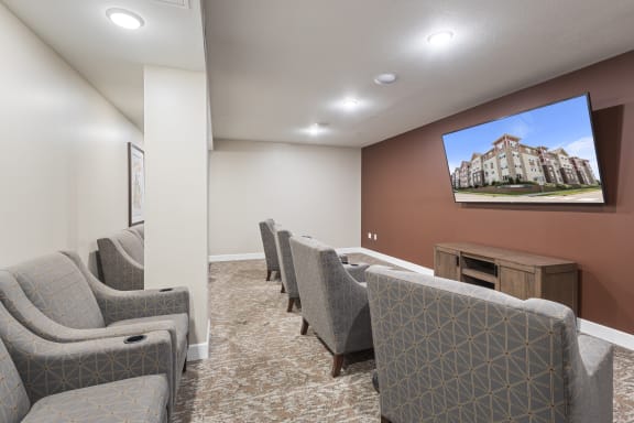 a community room with couches and chairs and a tv on the wall at The Winslow 62+ Apartments, West St Paul, MN, 55118