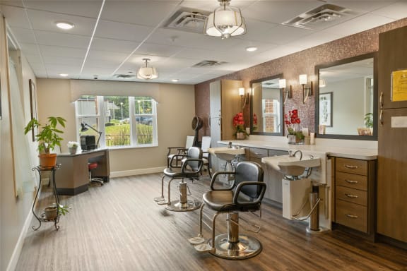 a salon room with chairs and sinks and mirrors at The Winslow 62+ Apartments, West St Paul