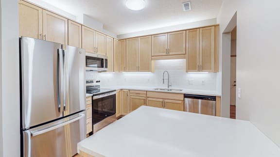 a kitchen with wooden cabinets and stainless steel appliances