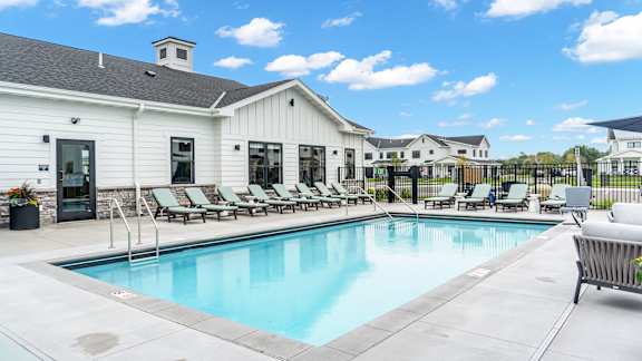 A large white building with a pool in front.