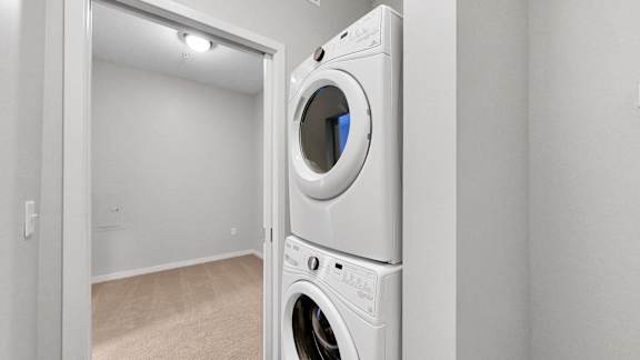 A white washing machine is in a small room.