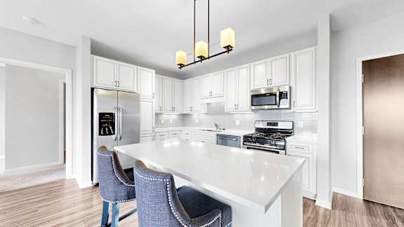 A kitchen with a white table and blue chairs.
