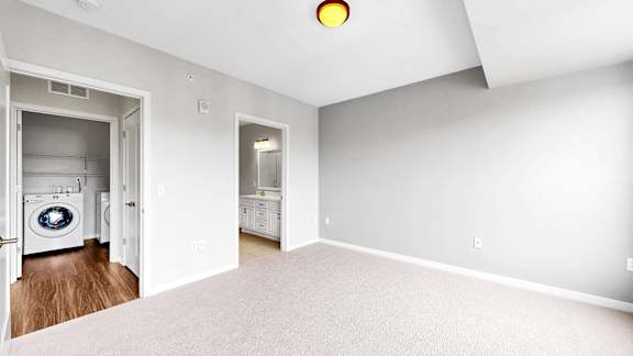 A laundry room with a washer and dryer is visible from the open door.