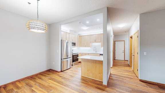 a renovated kitchen with white appliances and wood flooring