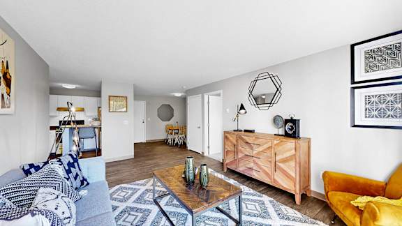 A living room with a yellow chair and a wooden coffee table.