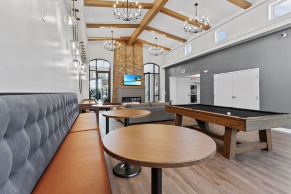 a common room with a pool table and couches