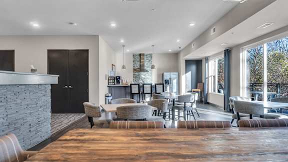 A modern living room with a stone fireplace and a large window.