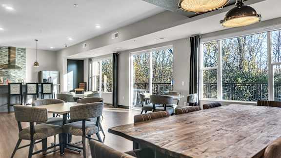 A modern dining room with a large wooden table and chairs.