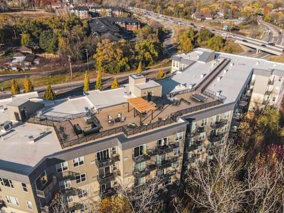 An aerial view of a multi-story apartment building surrounded by trees.