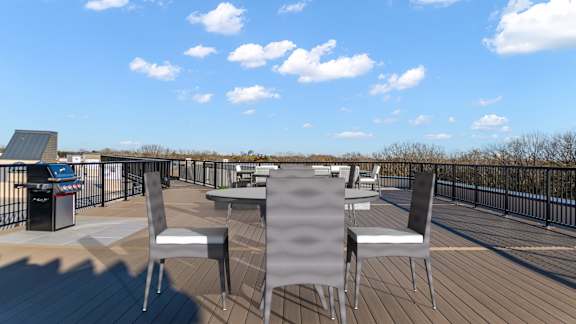 A deck with chairs and a table is set up on a sunny day.