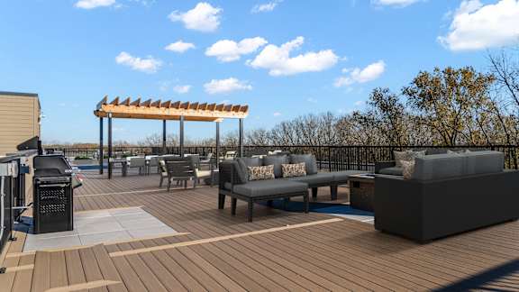 A wooden deck with a table and chairs and a canopy.