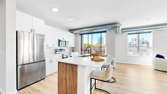 A modern kitchen with a wooden island and stainless steel appliances.