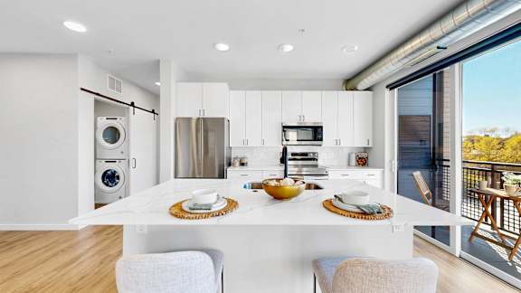 A modern kitchen with a dining table set for two.