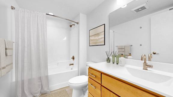 A white bathroom with a toilet, sink, and shower.