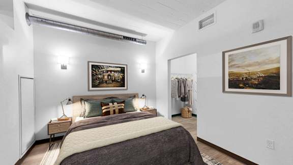 A bedroom with a large bed and two pictures on the wall.