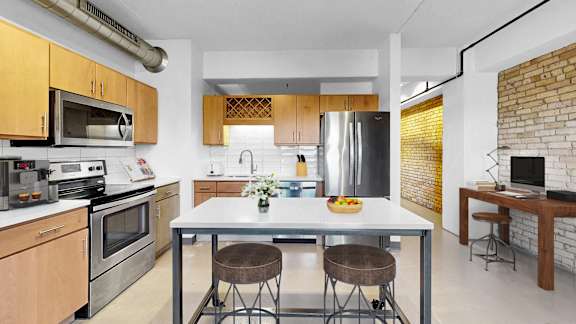 A modern kitchen with a table and chairs in the middle.