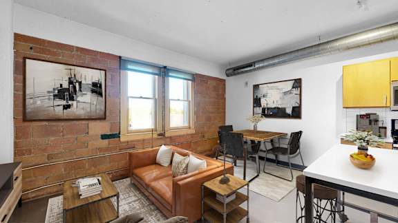 A living room with a brown couch and a coffee table.
