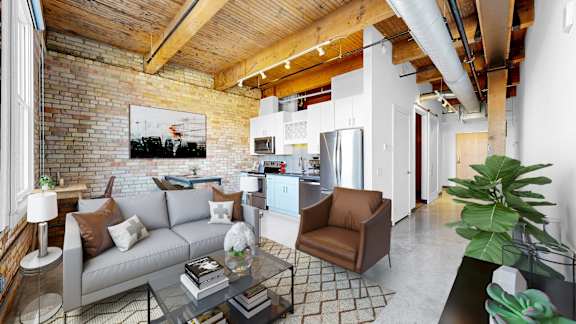A living room with a grey couch and a glass coffee table.