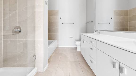 A bathroom with a white tub, sink, and toilet.