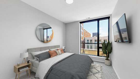 A bedroom with a large bed and a flat screen TV mounted on the wall.