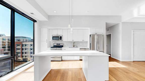 A modern kitchen with white cabinets and a large island.
