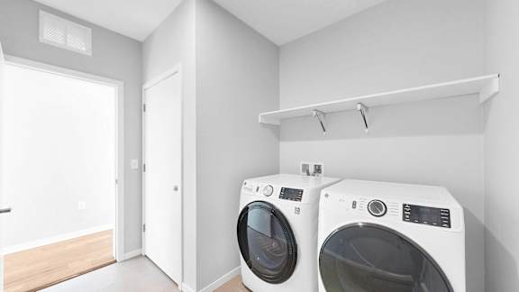 Two front load washing machines in a laundry room.