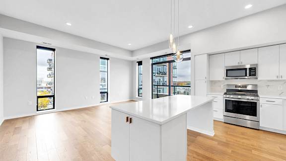 A modern kitchen with white cabinets and a large island.