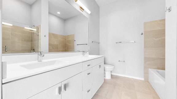 A bathroom with a white sink and a white toilet.