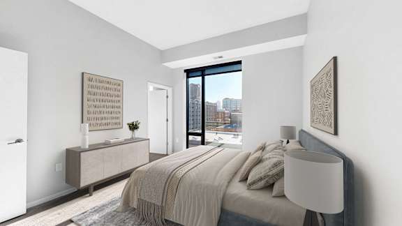 A bedroom with a large bed and a view of the city.